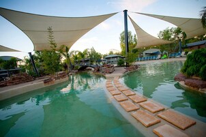 Una piscina al aire libre, sillones reclinables de piscina