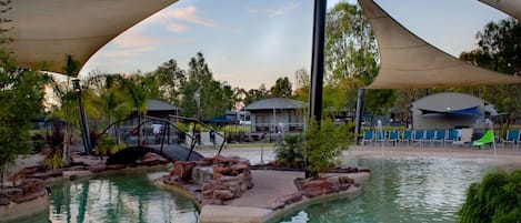 Una piscina al aire libre, sillones reclinables de piscina