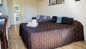Un dormitorio con una cama, un escritorio y una silla.