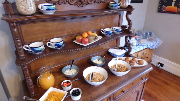 Montaje de un bufé de desayuno con diversos alimentos y bebidas.