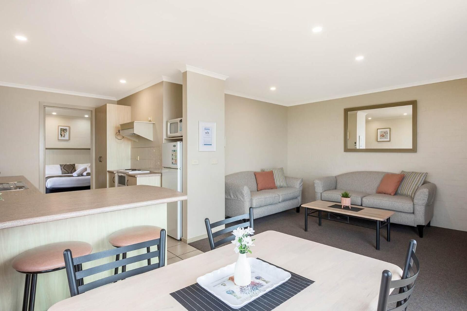 A compact living space with a kitchenette, a dining area, and a seating area with a sofa and a coffee table.