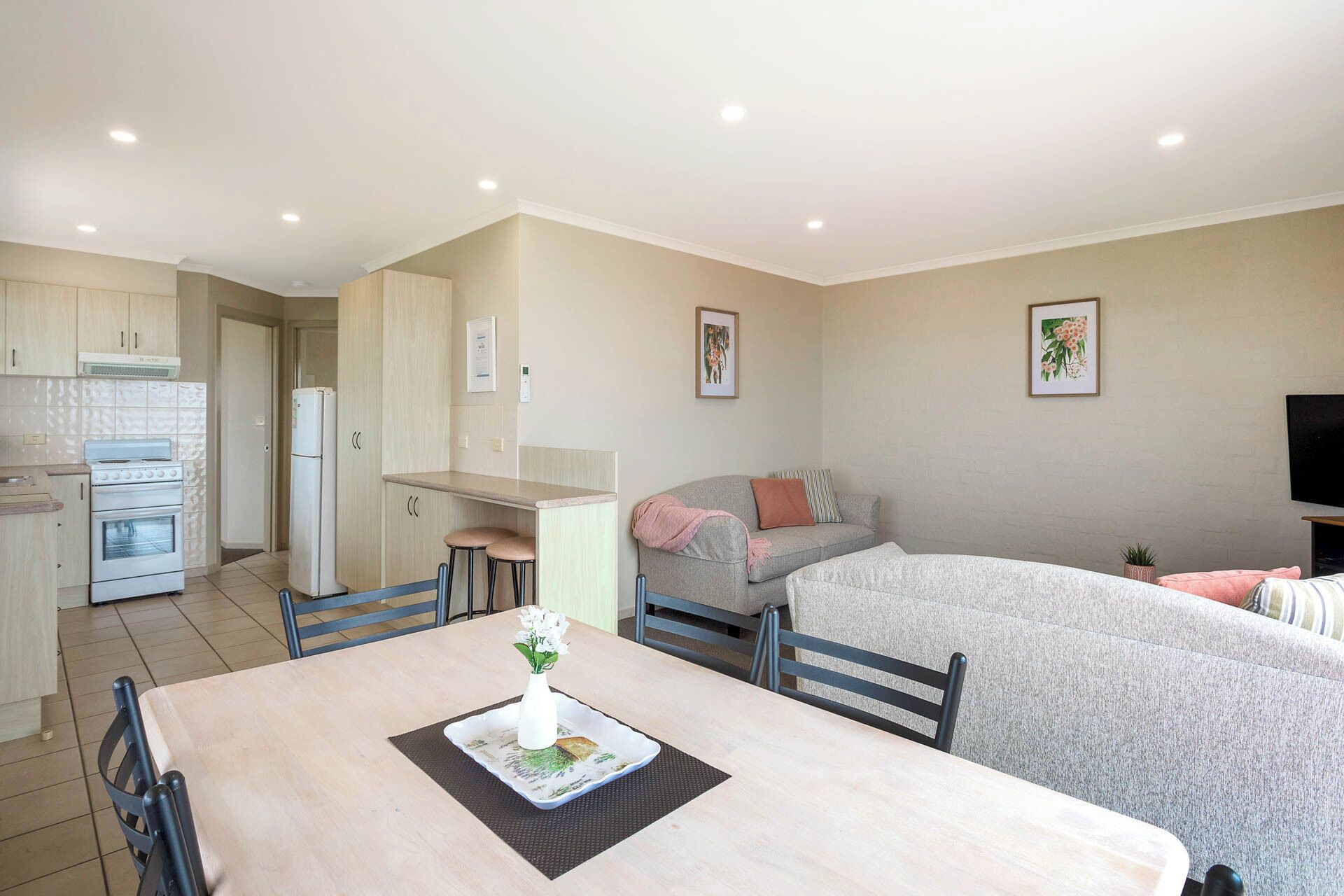A compact living space with a kitchenette, a dining area, and a sofa bed.