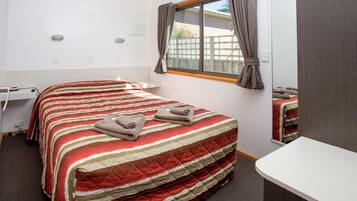 Una habitación de hotel con una cama, un escritorio y una ventana.