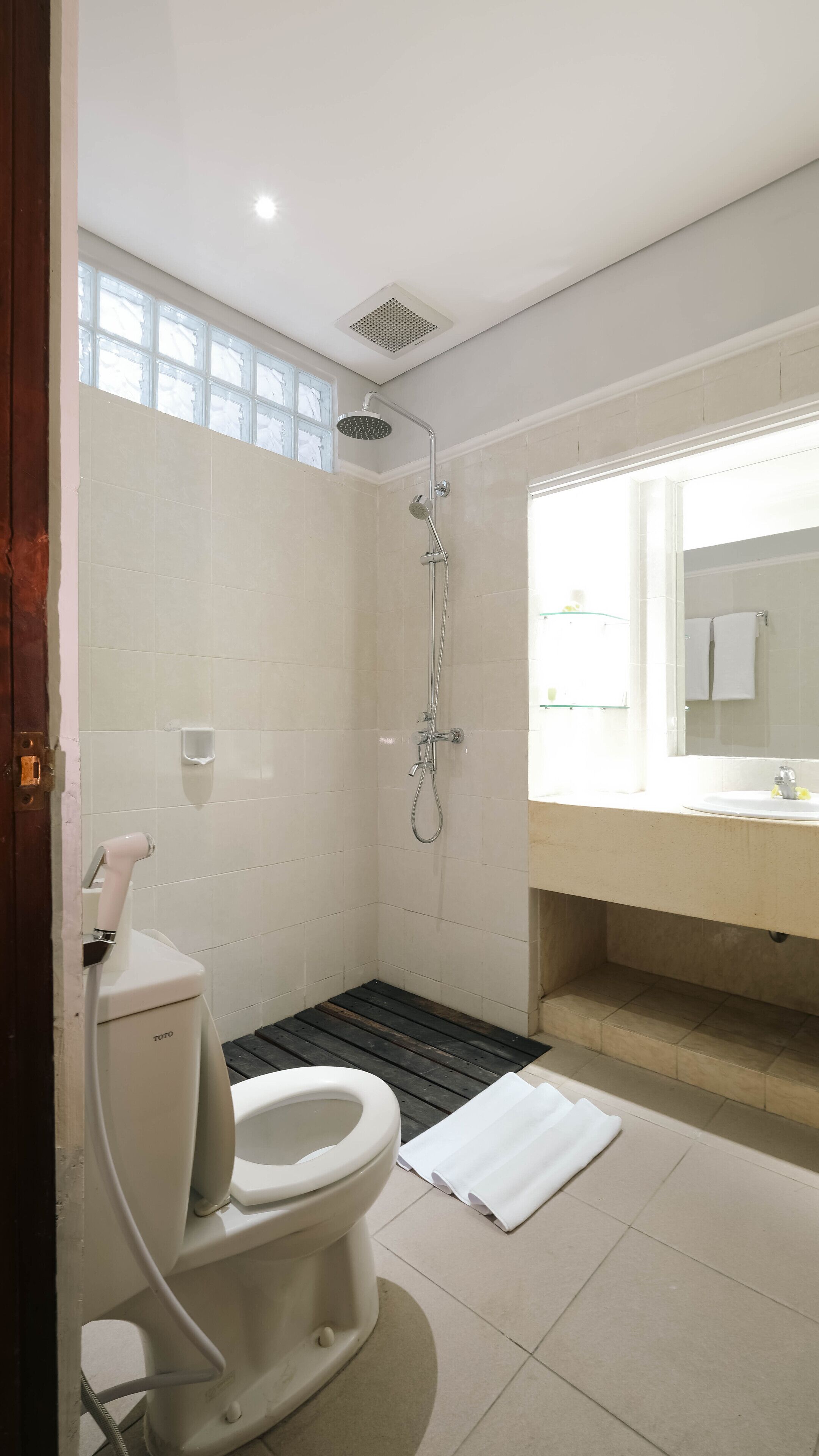 A modern bathroom with a toilet, shower, and sink.