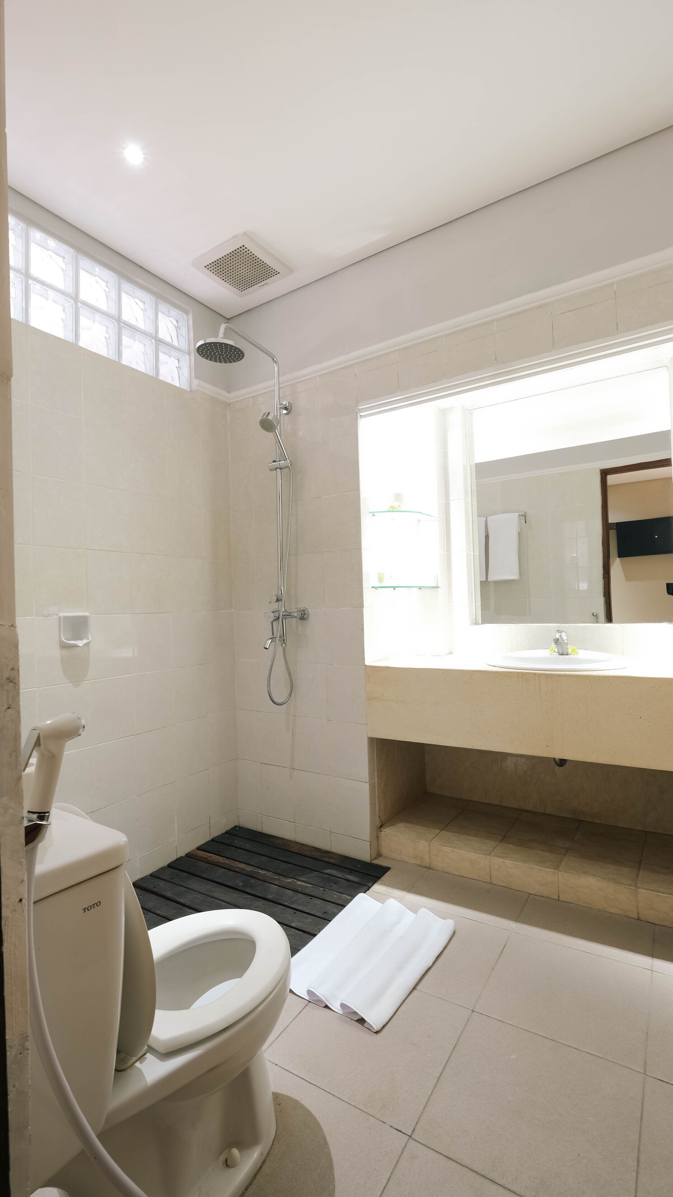 A modern bathroom with a toilet, shower, and sink.