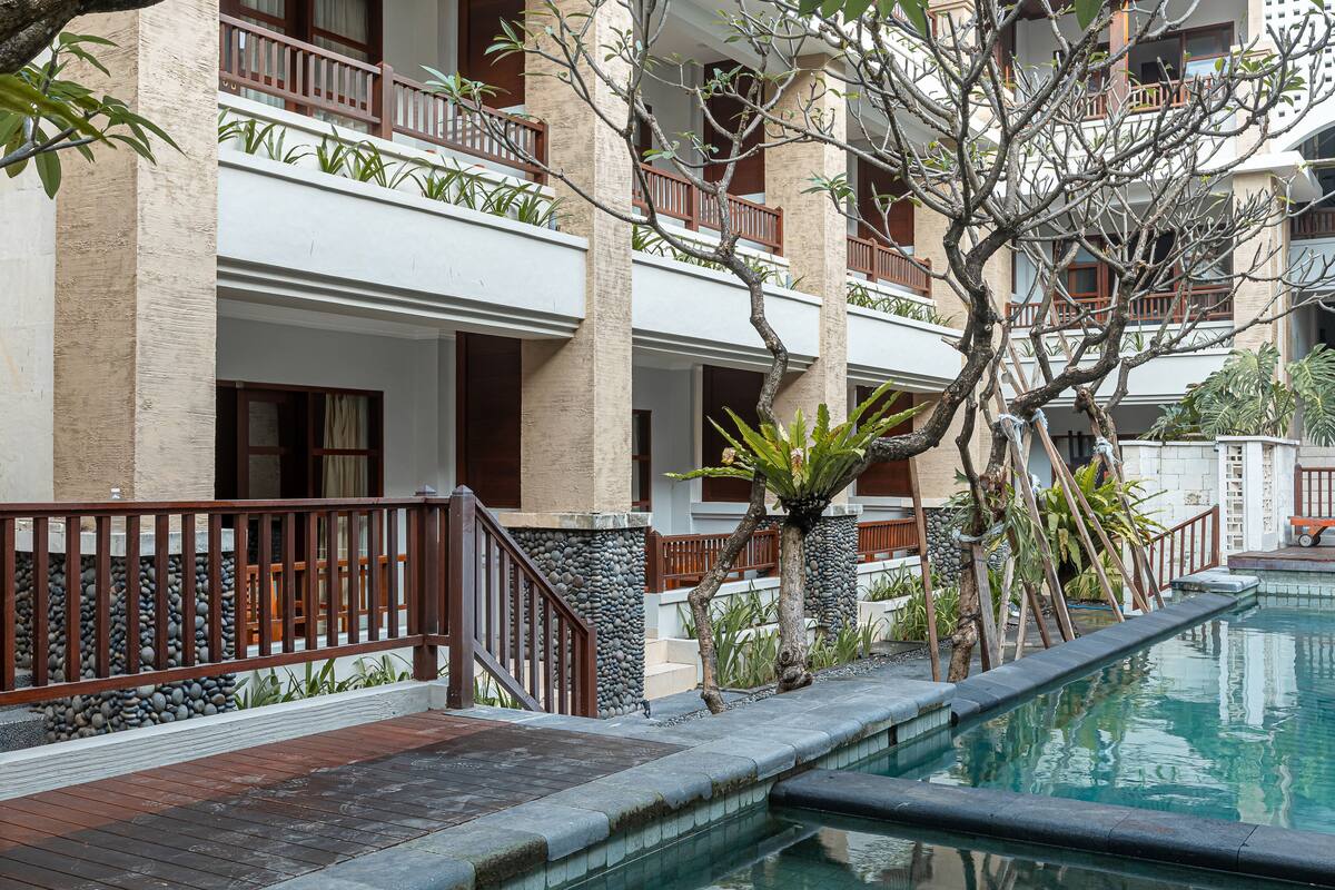 A hotel with a pool, wooden railings, and balconies.