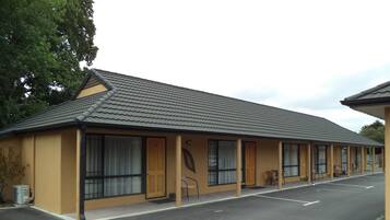 A motel with a single-story structure, a tiled roof, and a parking lot with directional arrows.