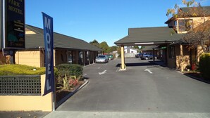 A motel with a covered parking area, a signboard for the South Park Motel, and a visible 'VACANCY' sign. - South Park Motel (Masterton)