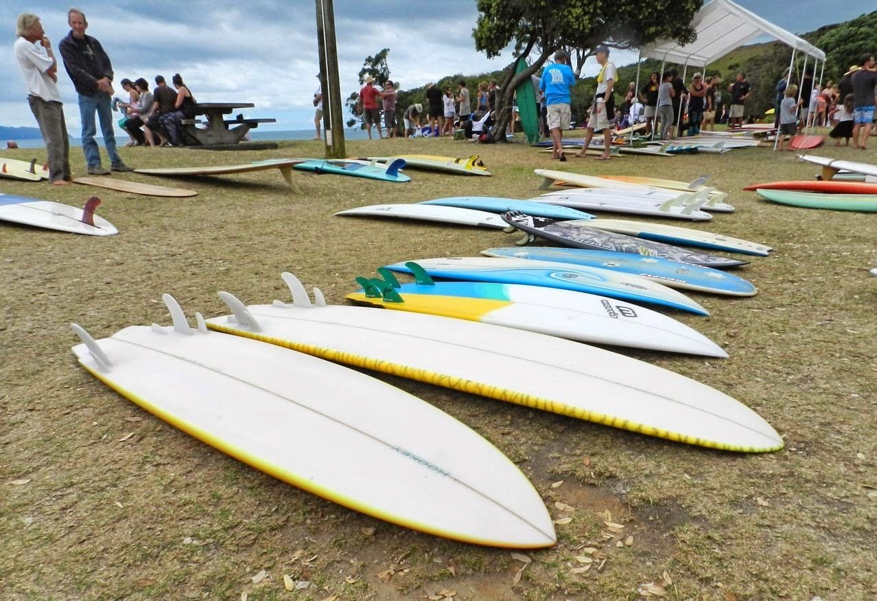 A grassy area with several surfboards lined up.