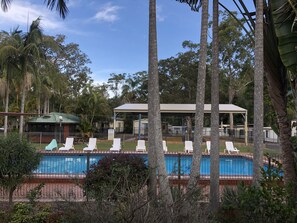A pool area with lounge chairs and a covered pavilion. - Twin Dolphins Holiday Park (Tuncurry)