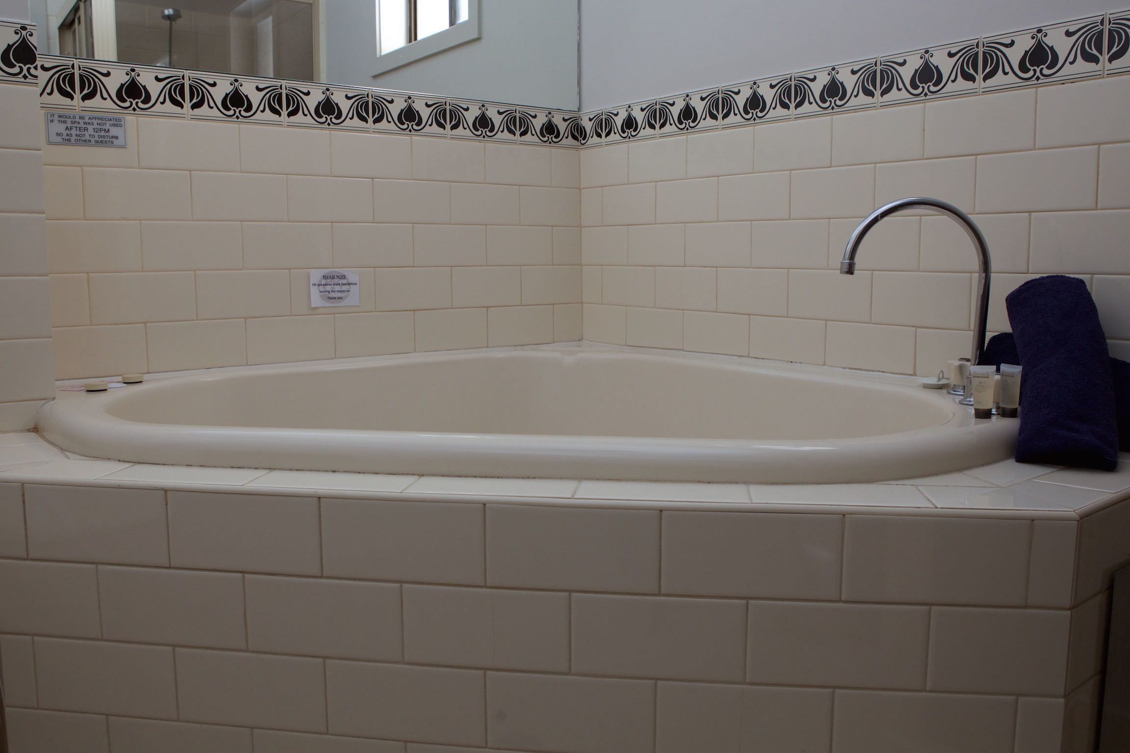 Een badkamer met een vrijstaand bad, een wastafel en een handdoekrek.