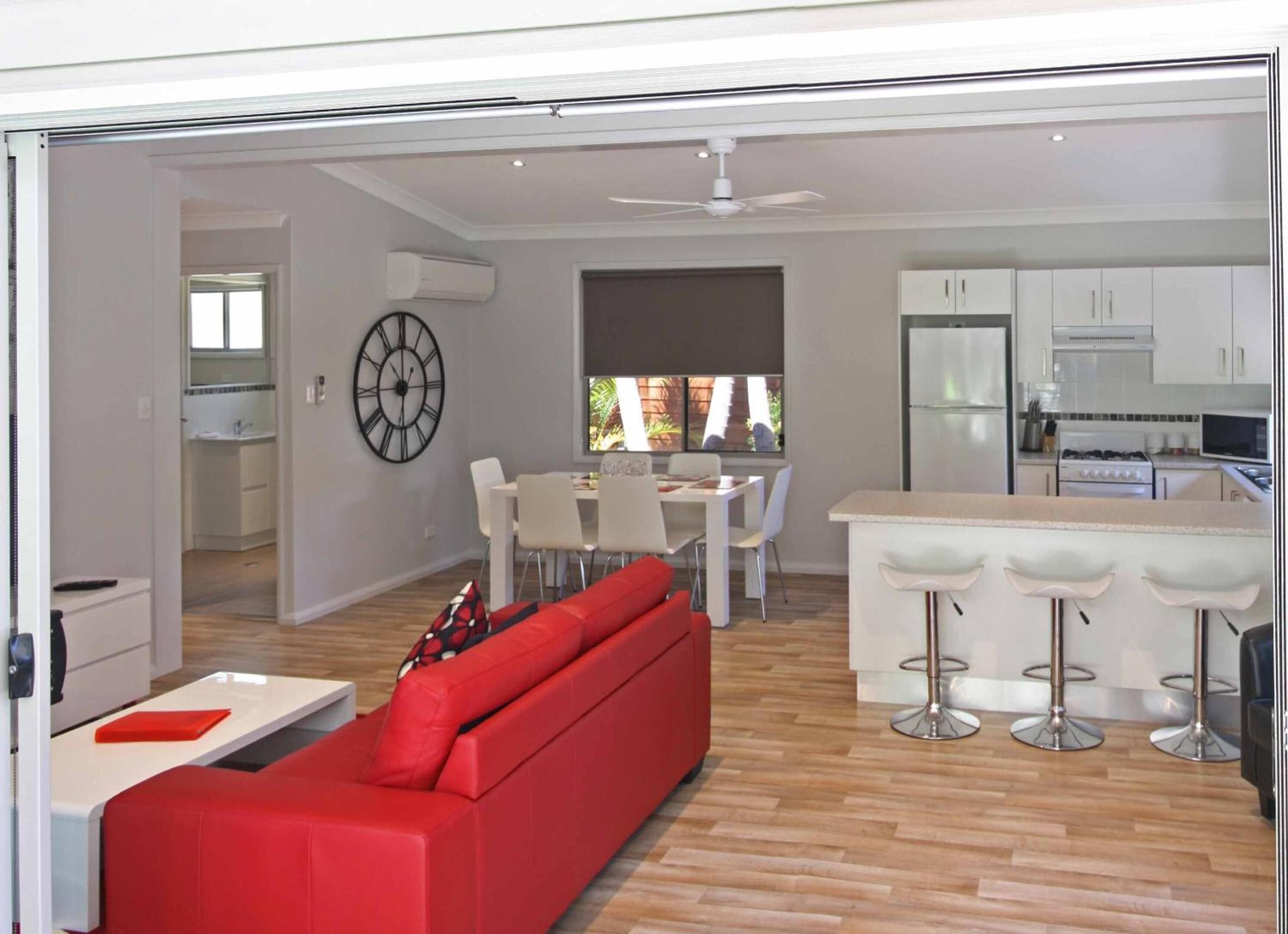 A modern kitchen with white cabinets, a refrigerator, and a stove.