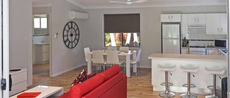 A modern kitchen with white cabinets, a refrigerator, and a stove.