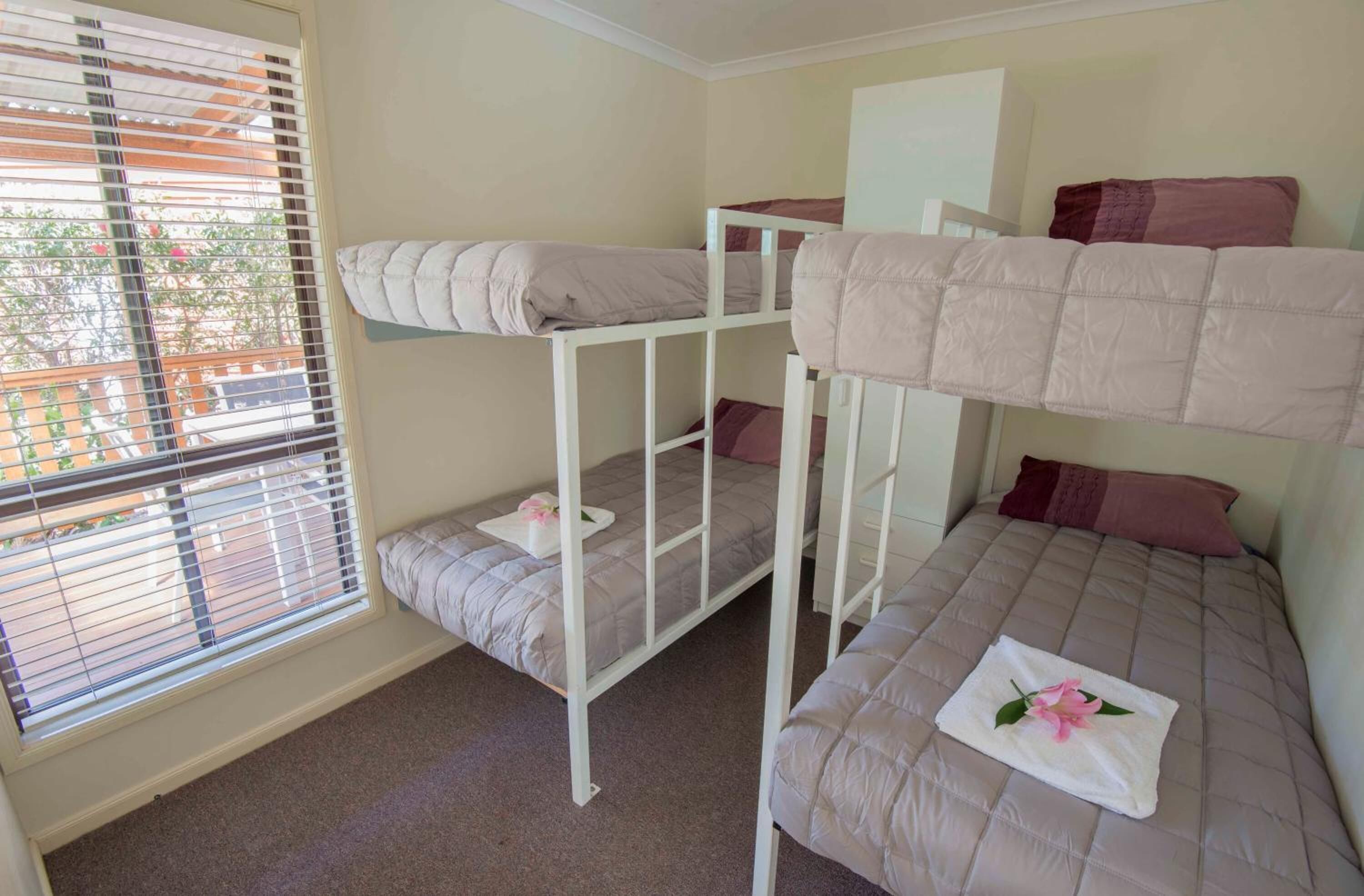 Een slaapkamer met een stapelbed, een raam en een deur.