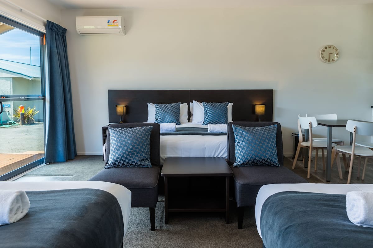 Une chambre d’hôtel comprenant un lit, deux tables de chevet, un bureau et une chaise.