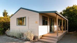 Een klein motel met één verdieping, een overdekte veranda en een bord waarop staat Park 3 Motel.