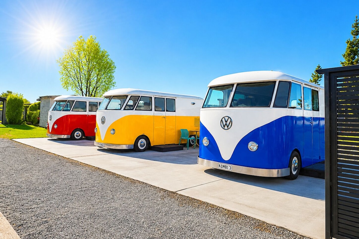 Three vintage VW vans parked in a row.