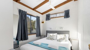 Een moderne hotelkamer met een groot bed, een bureau en een raam met gordijnen.