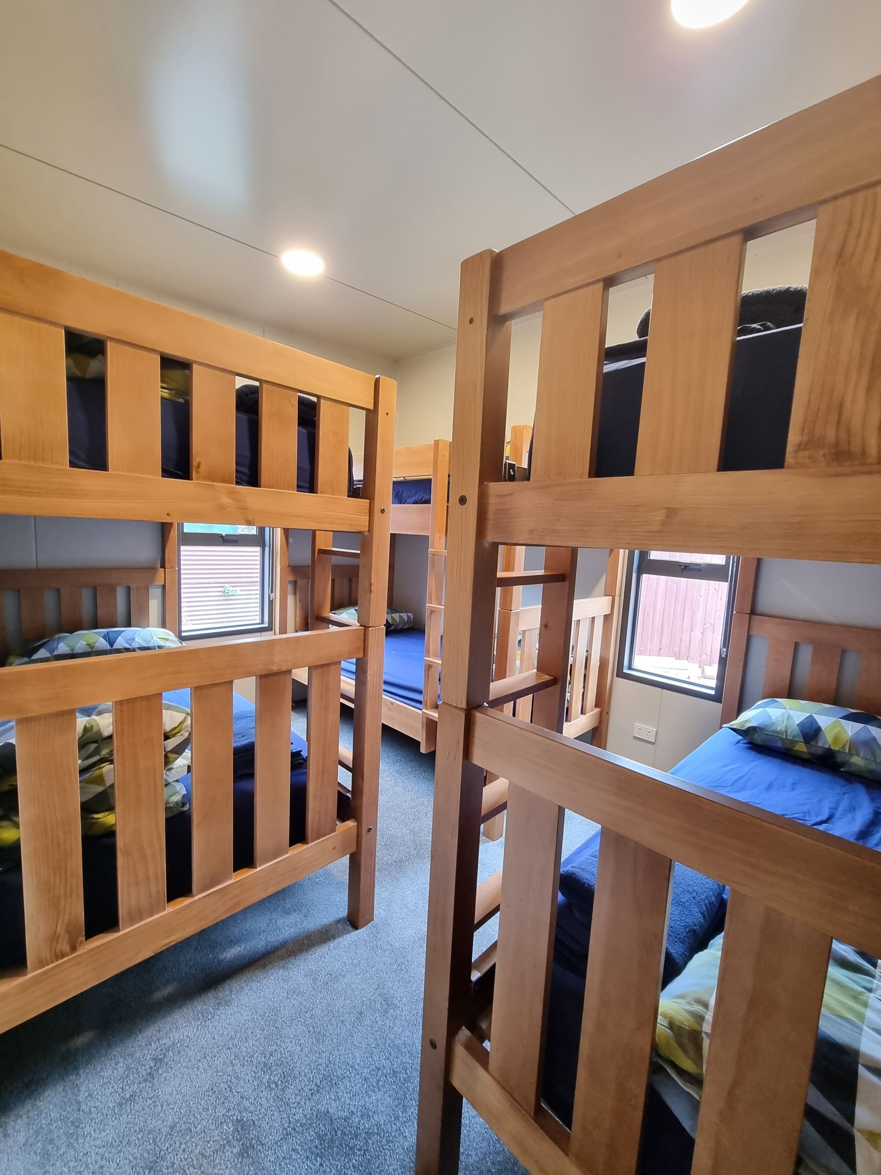 A dormitory room with bunk beds and a window.