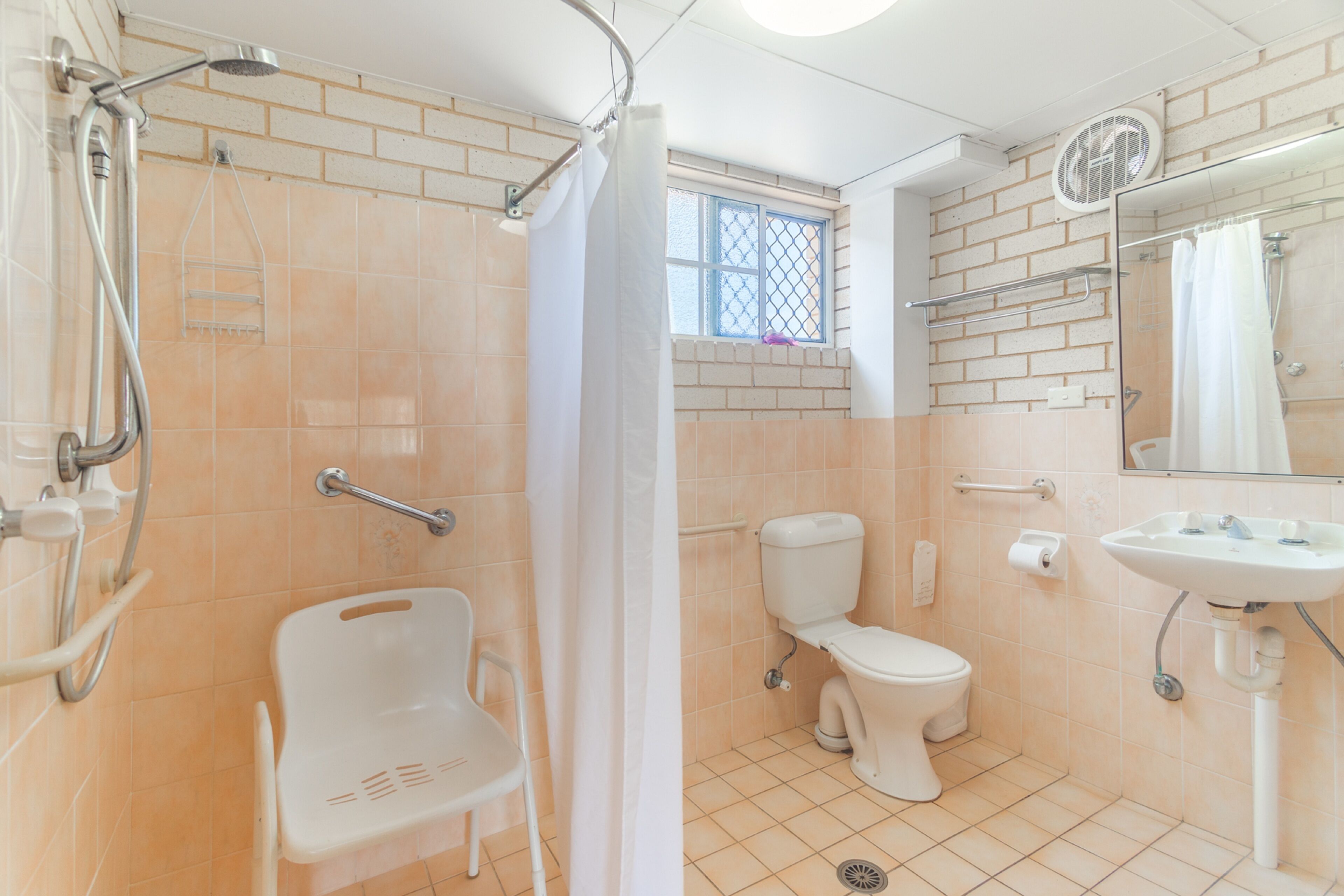 A bathroom with a shower, toilet, and sink.