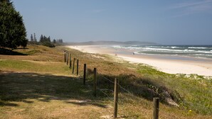 A beach with a wooden fence, grassy areas, and a clear sky. - Santa Fe Motel & Holiday Units (Lennox Head)