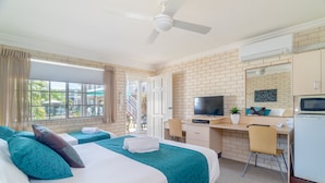 A hotel room with two beds, a desk, a TV, and a small kitchenette. - Santa Fe Motel & Holiday Units (Lennox Head)