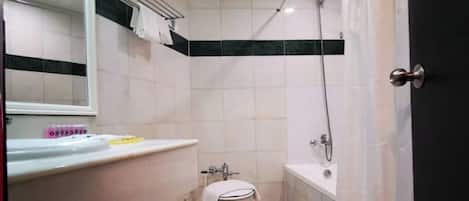 A compact bathroom with a toilet, sink, and shower.