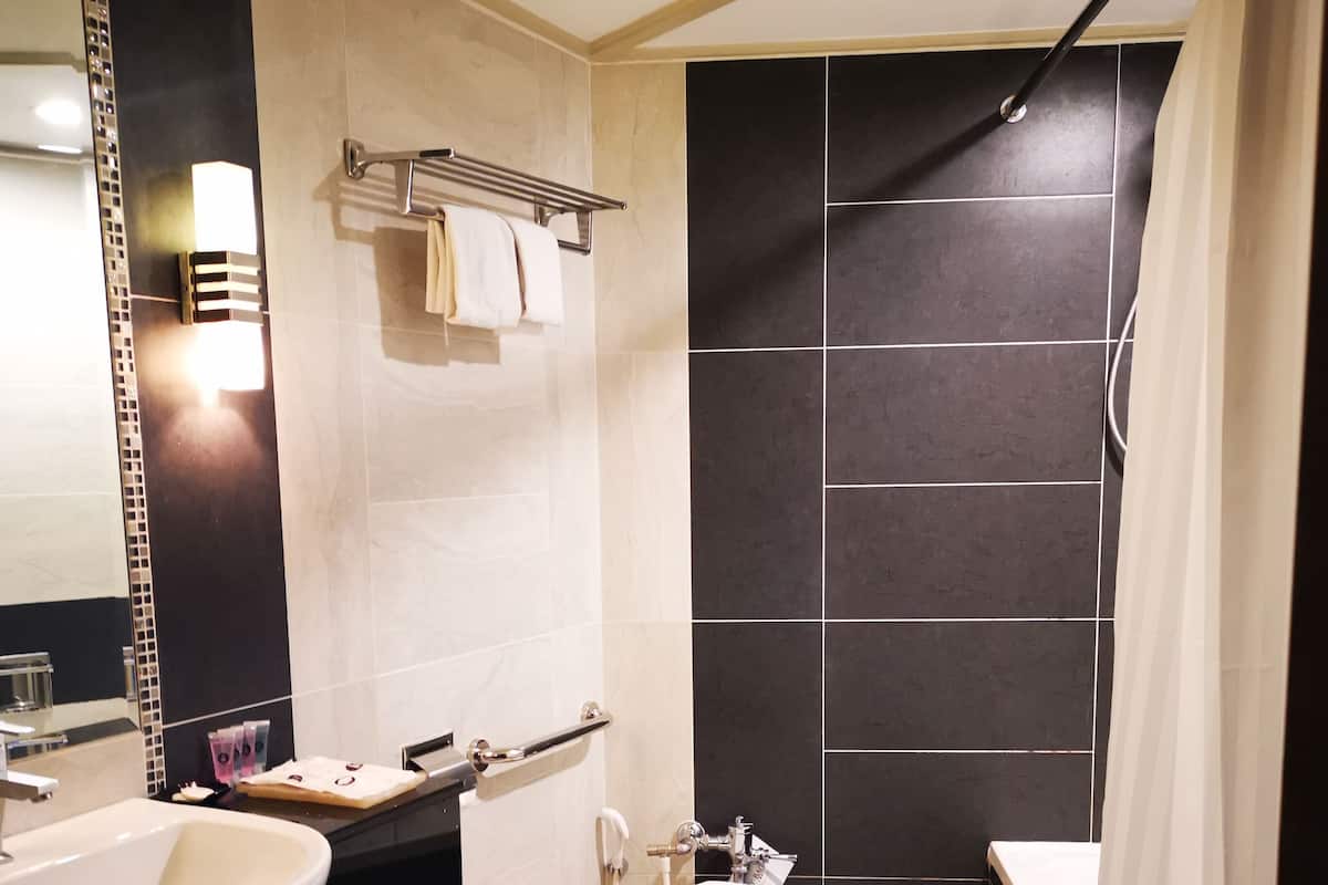 A modern bathroom with a sink, toilet, and shower.