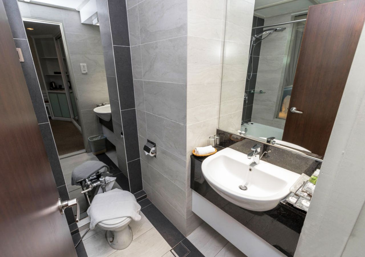 A modern bathroom with a toilet, sink, and shower.