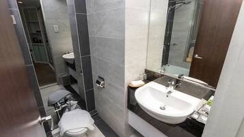 A modern bathroom with a toilet, sink, and shower.