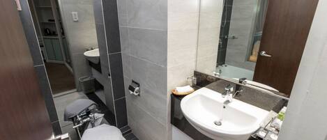 A modern bathroom with a toilet, sink, and shower.