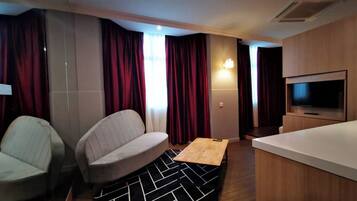 Studiosuite – executive, 1 soverom | Oppholdsområde | En 32-tommers LCD-TV med kabel-kanaler samt TV