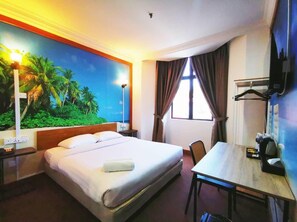 A hotel room with a bed, a desk, a chair, a TV, and a window with curtains. - REGALODGE HOTEL & SPA (Ipoh)