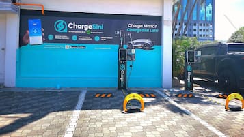 An electric vehicle charging station with a sign advertising Chargesini, a partnership with Mantech.