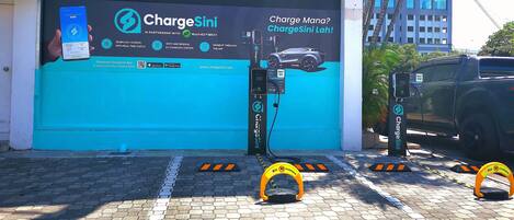 Une borne de recharge pour véhicules électriques, avec une enseigne faisant la publicité de Chargesini, un partenariat avec Mantech.