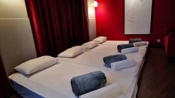 A hotel room with a large bed, red curtains, and a red wall.