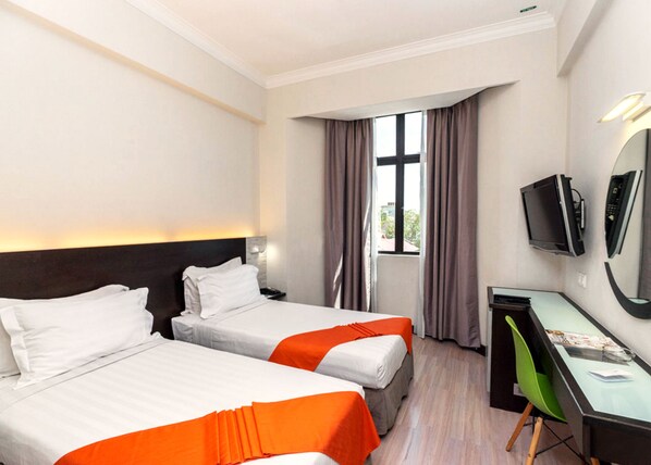 A hotel room with two beds, a desk, a chair, a television, and a window with curtains. - REGALODGE HOTEL & SPA (Ipoh)