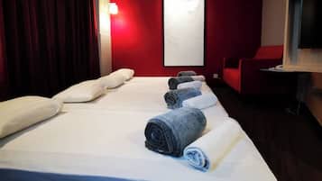 Una habitación de hotel con una cama grande, paredes rojas y una cortina roja.