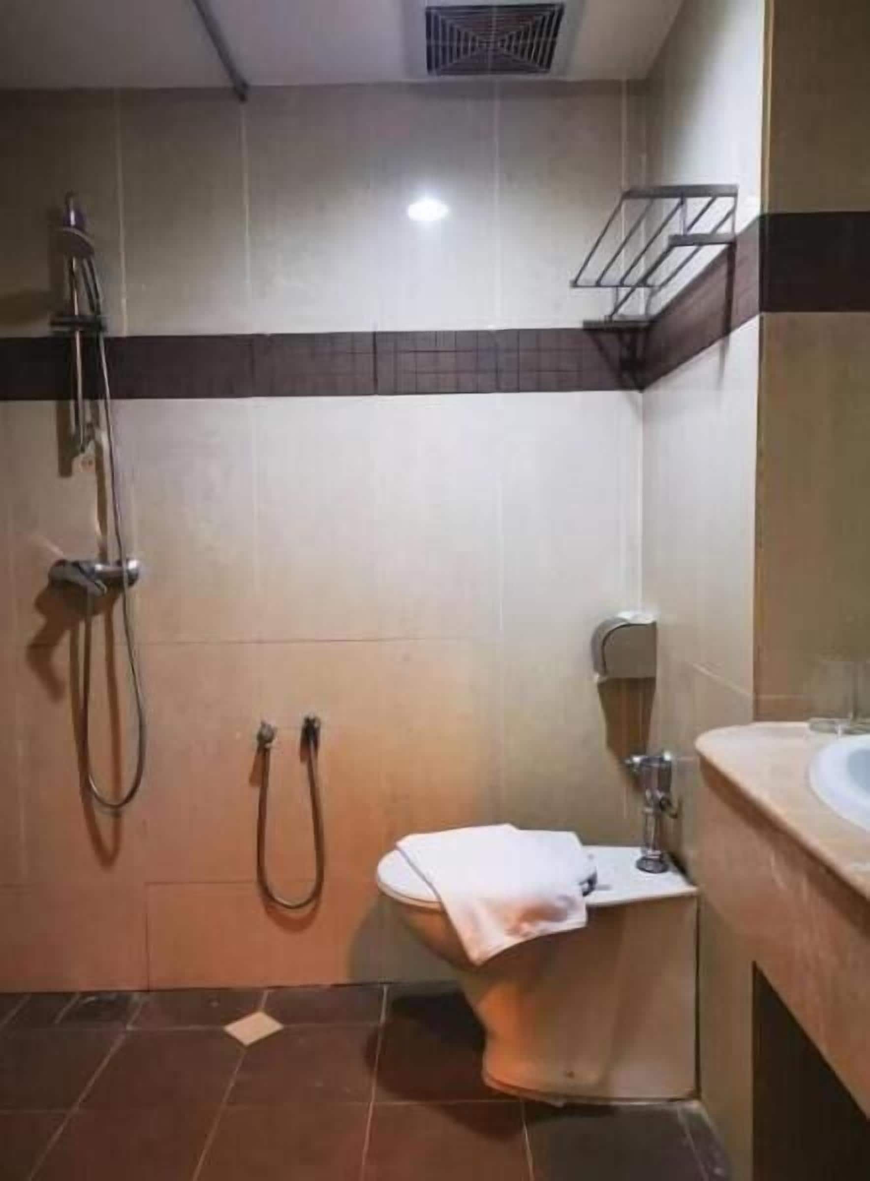 A small bathroom with a shower, toilet, and sink.