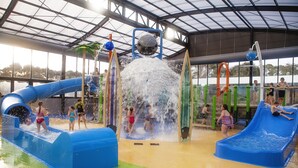 Parque aquático em ambiente fechado, com escorregadores e atrações aquáticas.