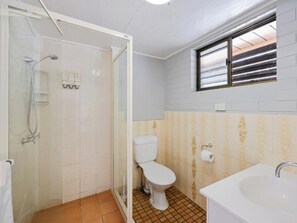 A bathroom with a shower, toilet, and sink.