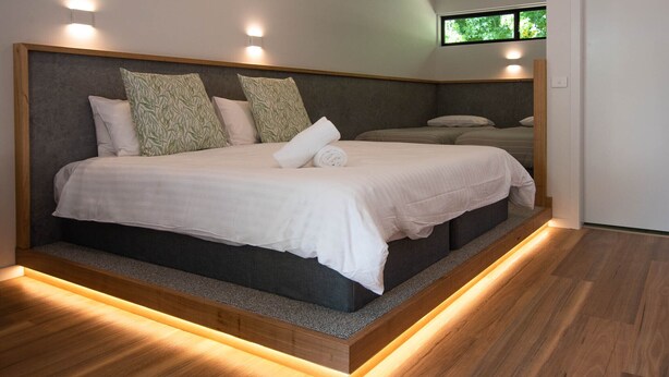Ein modernes Schlafzimmer mit einem großen Bett, zwei Nachttischen und einem Fenster.