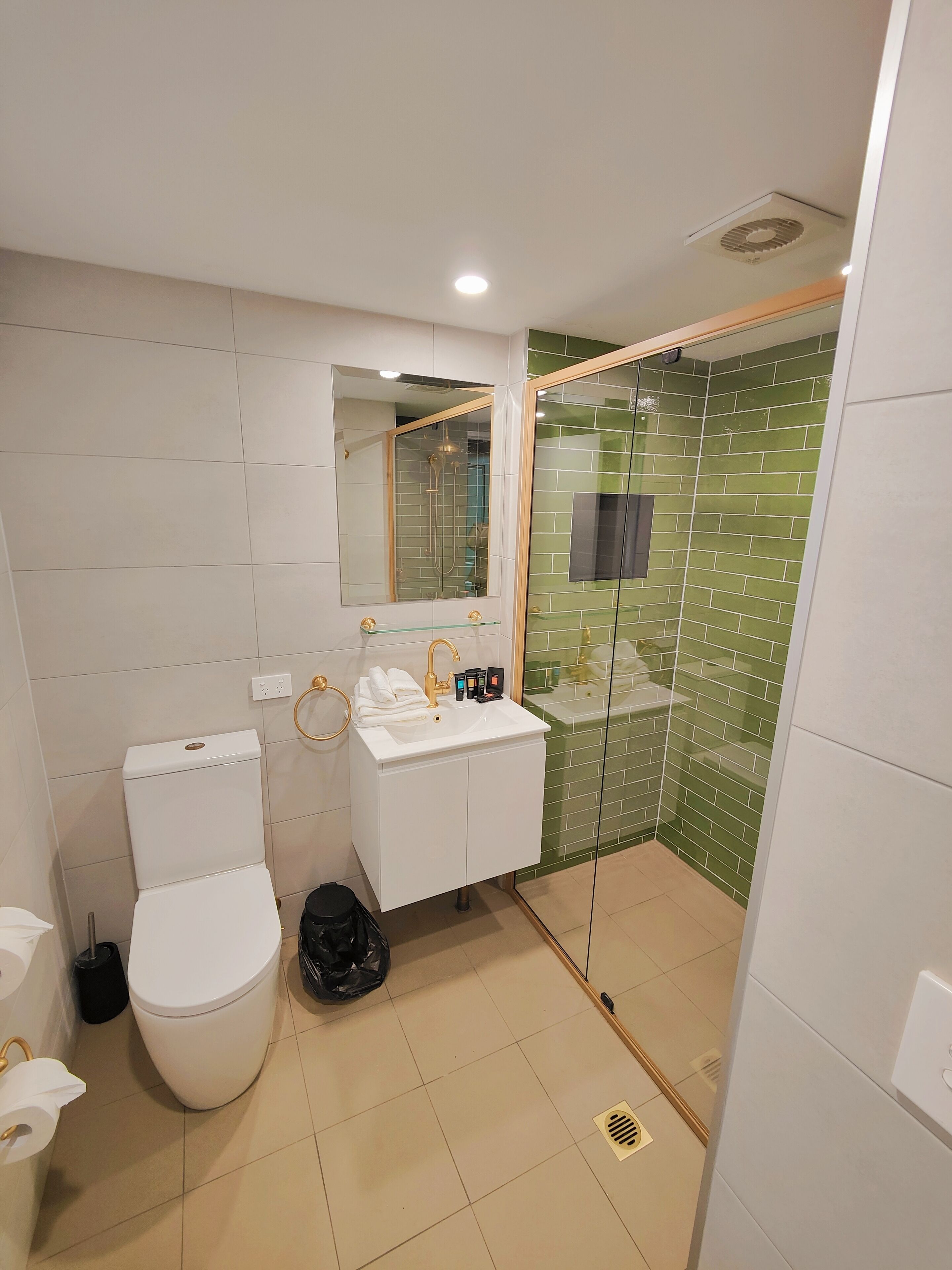 Een moderne badkamer met toilet, wastafel en douche.