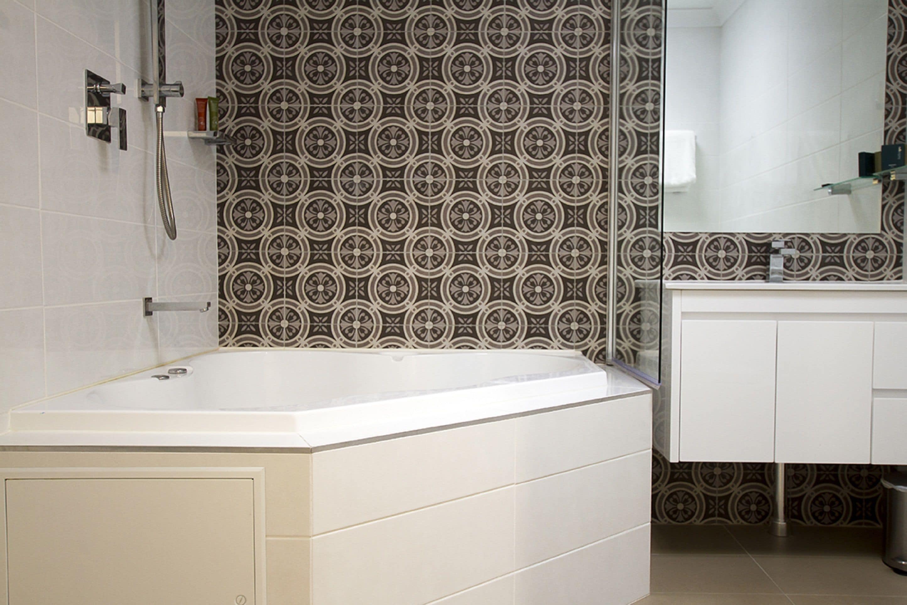 Ein modernes Badezimmer mit Badewanne, Dusche und Waschtisch mit Spiegel.