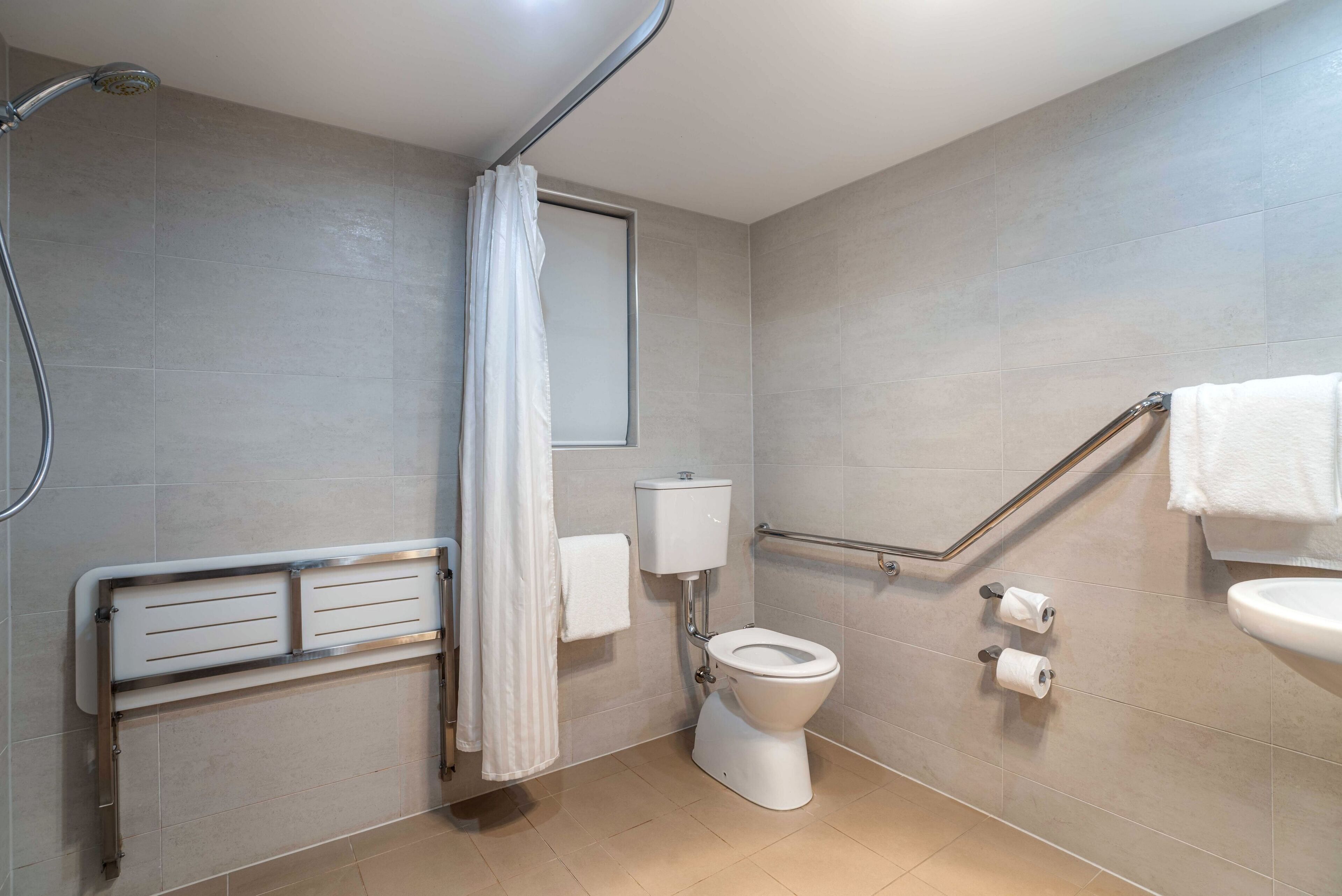 A bathroom with a shower, toilet, and sink.