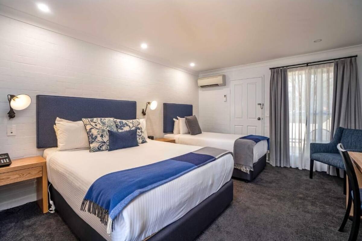 Una habitación de hotel con dos camas, un escritorio y una silla.