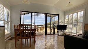 Amplia sala de estar con una mesa de comedor, sillas, sofá y televisor.