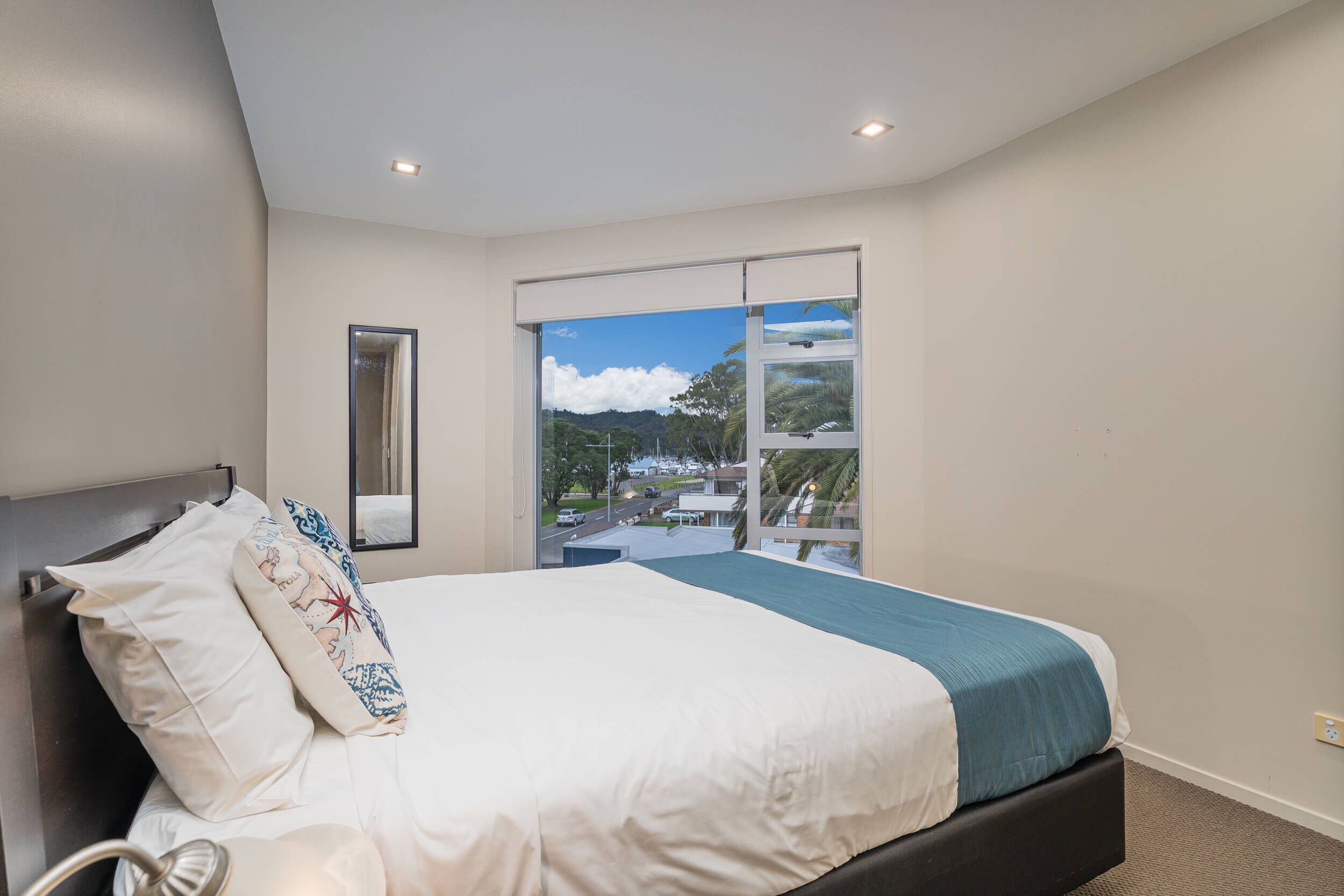 A bedroom with a bed, a window with a view, and a ceiling light.
