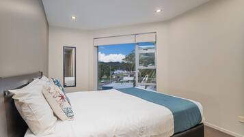 A bedroom with a bed, a window with a view, and a ceiling light.