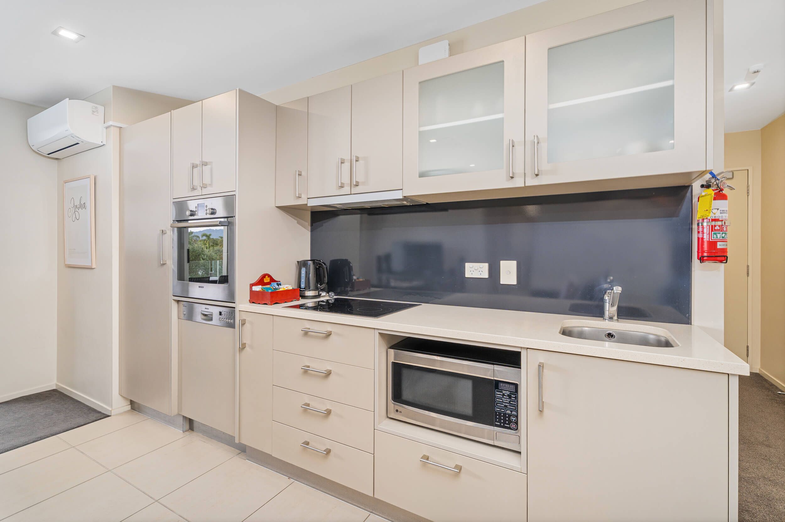 A modern kitchen with a built-in oven, microwave, and sink.